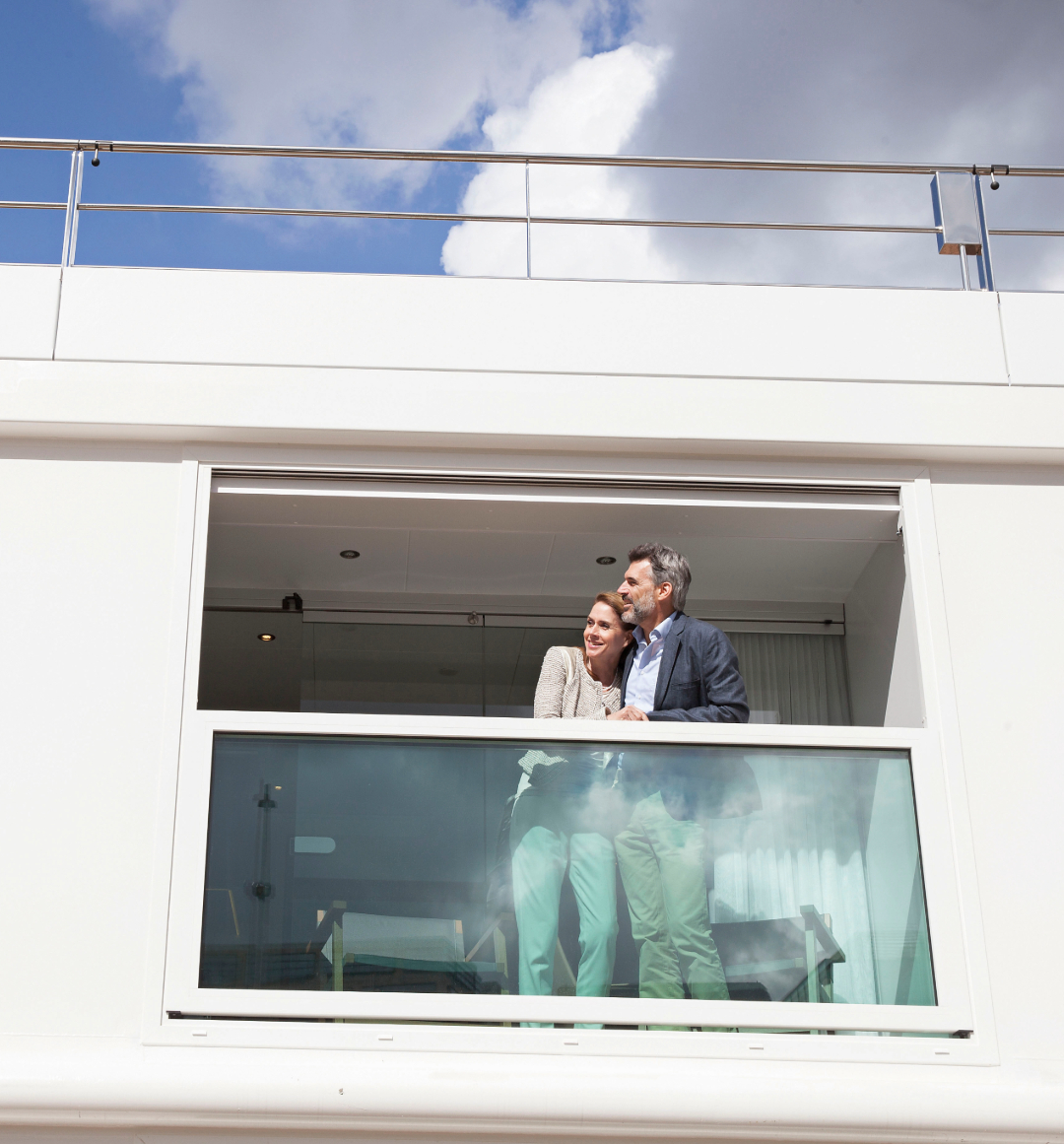 Couple looking off the balcony of Emerald river cruise