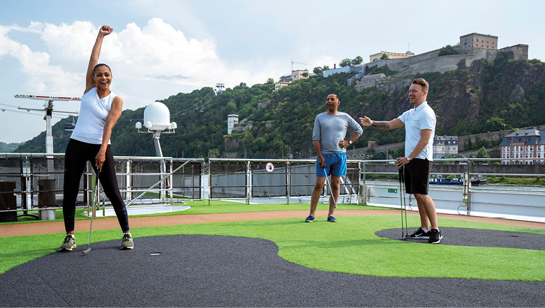 Three cruise guests enjoying the putting green