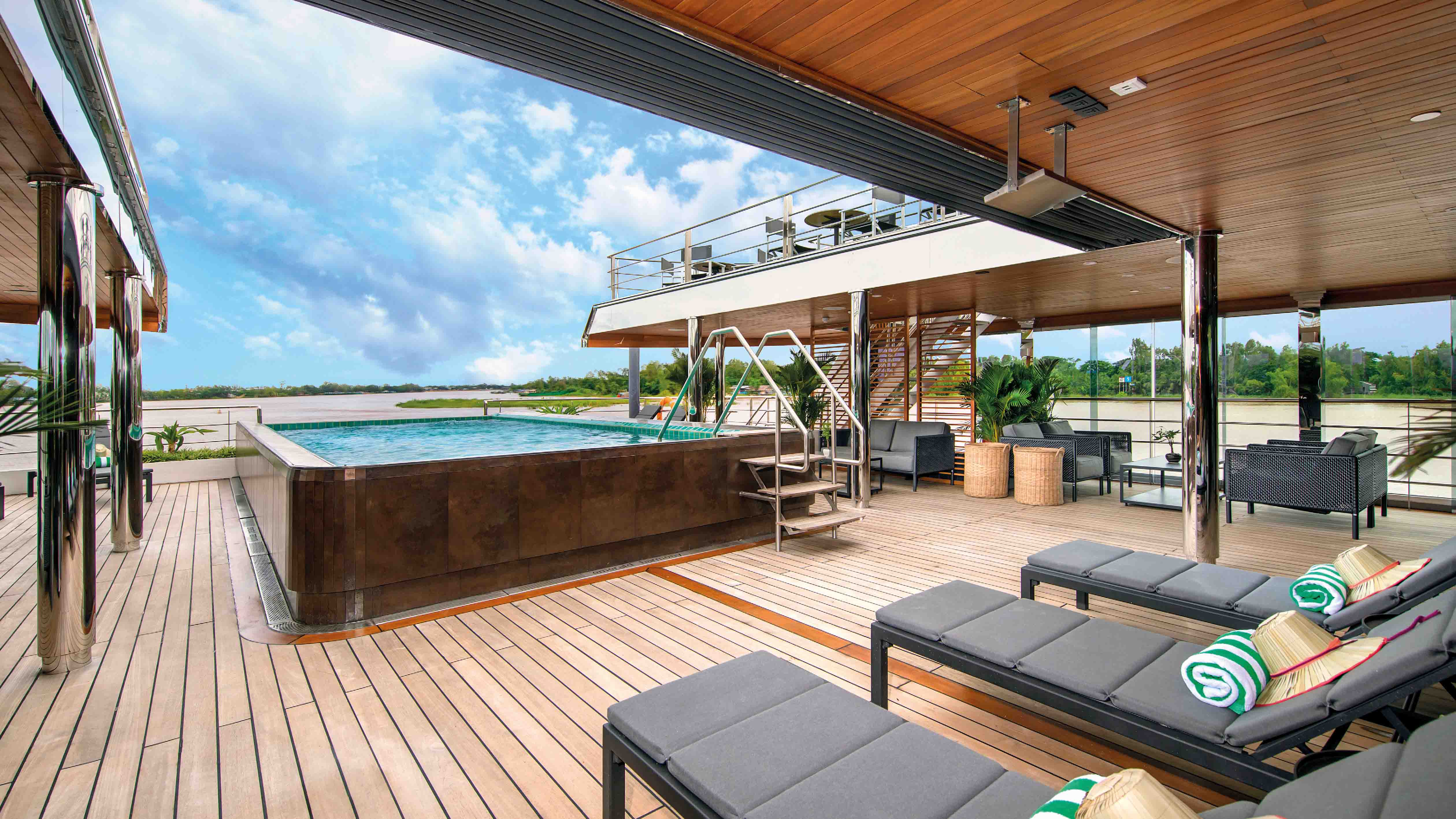 Pool and sun beds on board a luxury river ship sailing the Mekong in Southeast Asia
