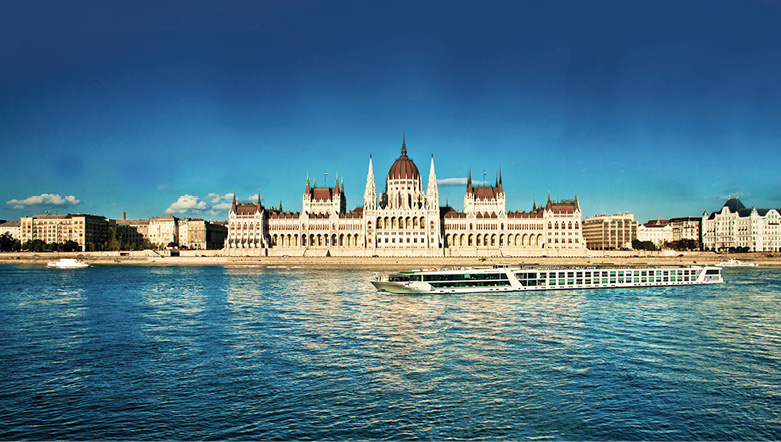 An Emerald Cruises luxury river ship sailing down the Danube in Budapest in front of the Parliament building