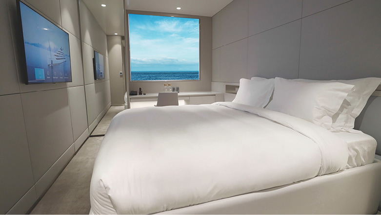 A spacious cabin on board an Emerald Cruises yacht cruise with a large picture window and views out across the ocean